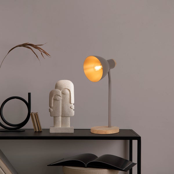 Dekorative Tischszene mit Lampe, Skulptur und Büchern auf einem schwarzen Regal.