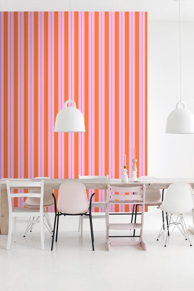 Esszimmer mit gestreifter Tapete und Holztisch mit Stühlen.