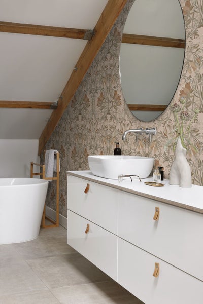 Badezimmer mit Waschbecken, Spiegel und floraler Tapete
