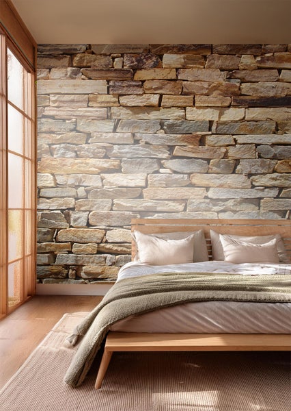 Schlafzimmer mit Steinwandtapete, Bett und Fenster