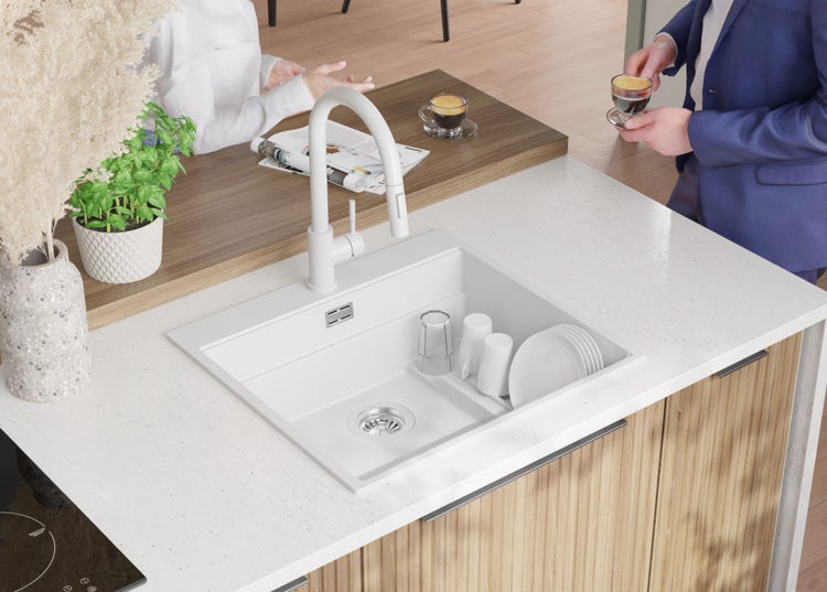 Spüle mit Geschirr und Armatur in einer hellen Küche.