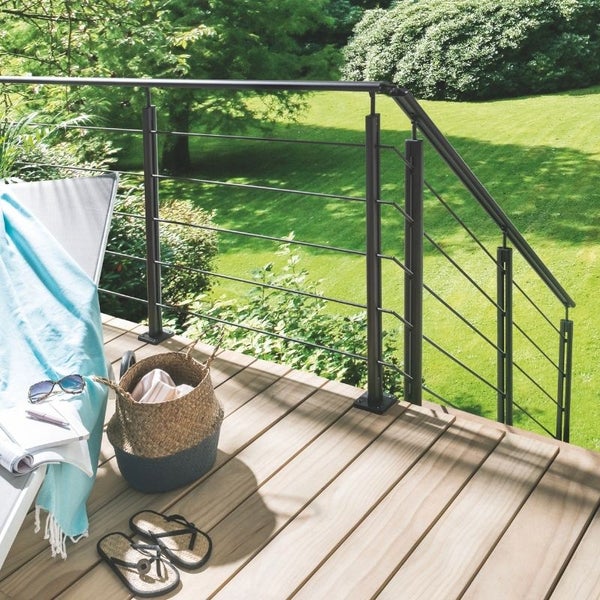 Terrasse mit Holzdeck und Metallgeländer vor Rasenfläche