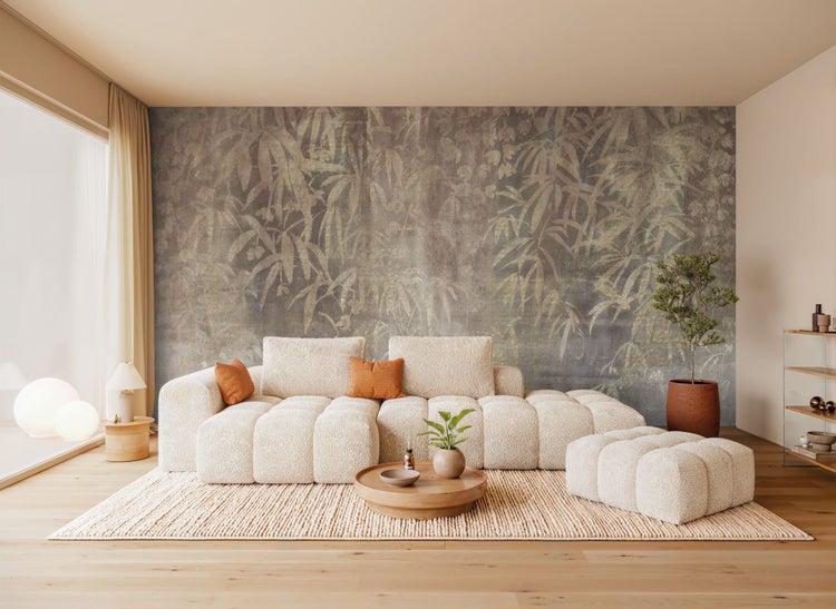 Wohnzimmer mit modularem Sofa, Teppich, Wandtapete mit Pflanzenmuster und dekorativen Elementen für ein gemütliches Ambiente.