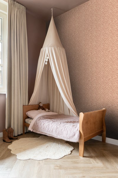Kinderzimmer mit Himmelbett, Holzbett und gemusterter Tapete