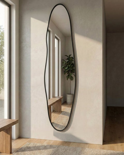 Wandspiegel mit unregelmäßiger Form und schmalem Rahmen im Wohnzimmer