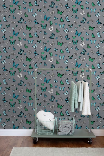 Raumansicht mit Tapete mit Schmetterlingsmuster, Kleiderständer und Accessoires