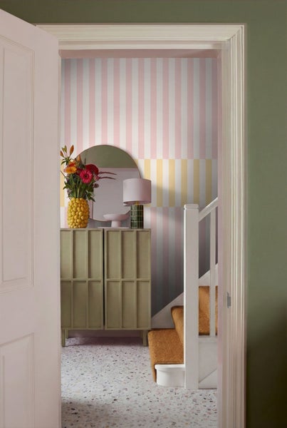 Flur mit gestreifter Tapete, Spiegel, Kommode und Treppe