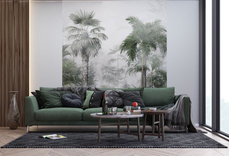 Wohnzimmer mit grünem Sofa, Couchtischen und tropischer Fototapete