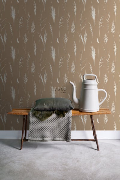 Dekorative Wand mit Gras-Motiv, ergänzt durch eine Bank mit Kissen und Gießkanne für eine gemütliche Atmosphäre.