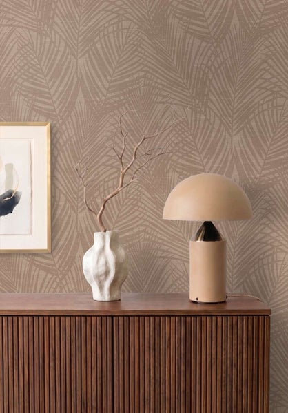 Moderne Vliestapete mit Palmblattmuster auf einer Holzanrichte mit Tischlampe und Blumenvase