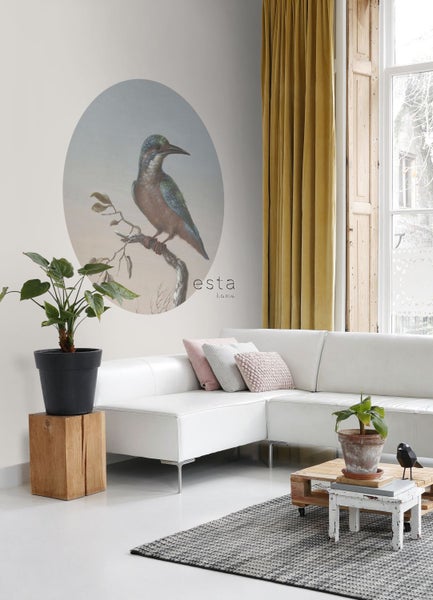 Wohnzimmer mit Wandbild eines Vogels, Sofa, Vorhängen und Pflanzen