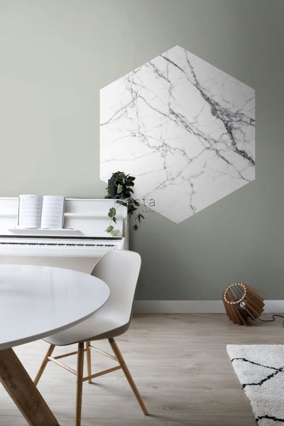 Wohnraum mit Esstisch, Klavier und sechseckiger Wanddekoration in Marmoroptik