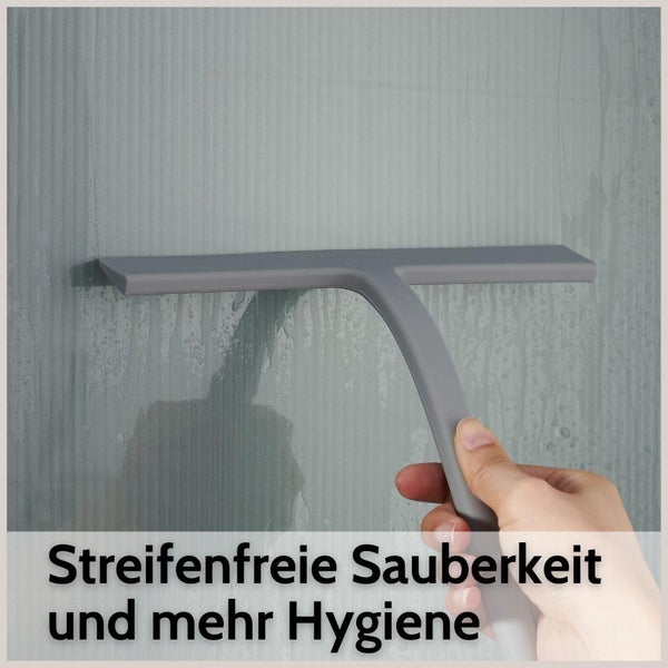 Hand führt einen Duschabzieher über eine nasse Glaswand für eine streifenfreie Reinigung.