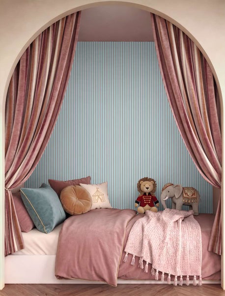 Kinderzimmer mit gestreifter Tapete, einem Bett mit vielen Kissen, Decken und Kuscheltieren, eingerahmt von einem Torbogen mit schweren Vorhängen.