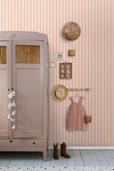 Einrichtung eines Kinderzimmers mit Schrank, Accessoires und gestreifter Tapete