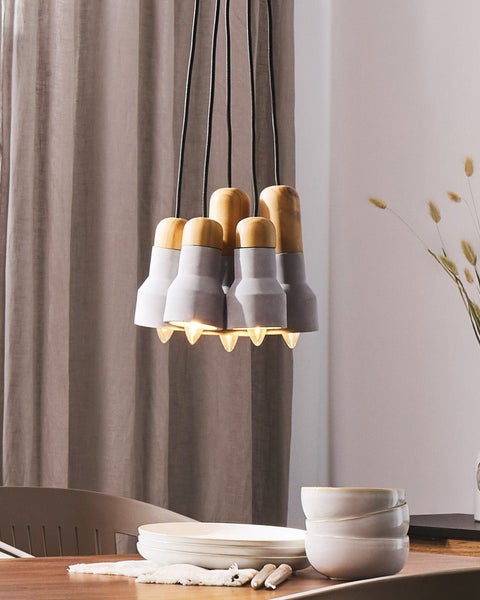 Hängelampe mit Holz- und Betonelementen über einem Esstisch