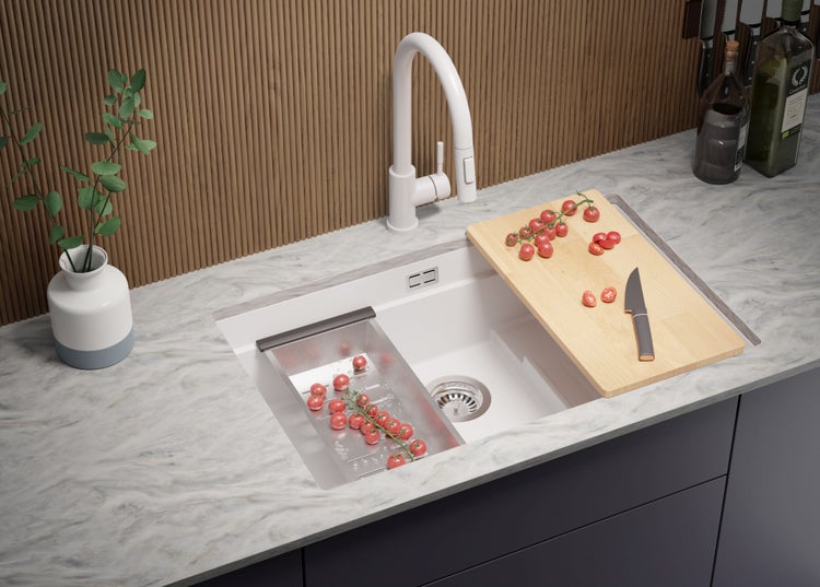Küchenspüle mit Schneidebrett, Abtropfsieb, Armatur und Lebensmitteln auf der Arbeitsplatte