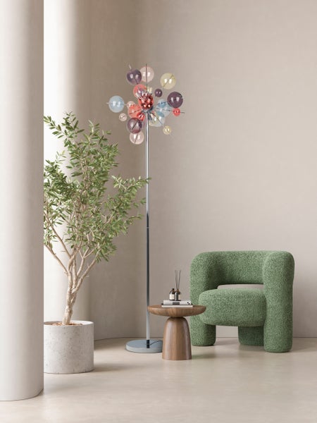 Wohnzimmer mit Stehlampe, Sessel, Beistelltisch und Pflanze