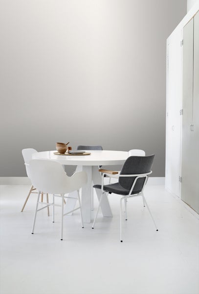 Heller Essbereich mit rundem Tisch und Stühlen vor einer dezenten Wand