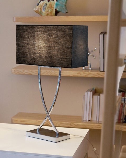 Tischleuchte mit rechteckigem Schirm und Metallfuß auf einem Tisch