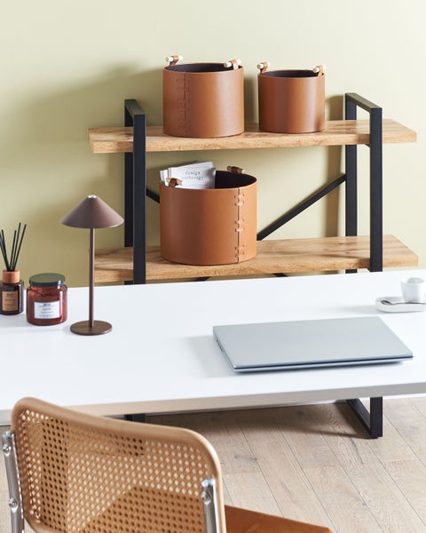 Szene eines Arbeitsbereichs mit Schreibtisch, Laptop, Ablagekörben und Regalen