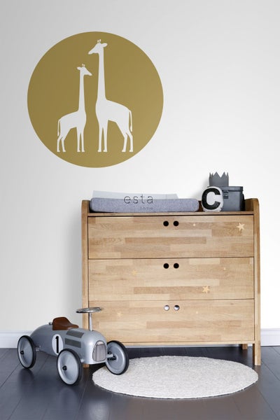 Dekoratives Kinderzimmer mit Holzkommode, Wandtattoo mit Giraffenmotiv und Spielzeugauto