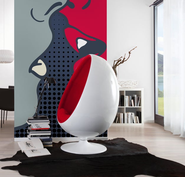 Moderner Wohnraum mit weißem Sessel in Eiform, einer Fototapete im Pop-Art-Stil, dunklem Fellteppich und hellem Boden in Holzoptik.