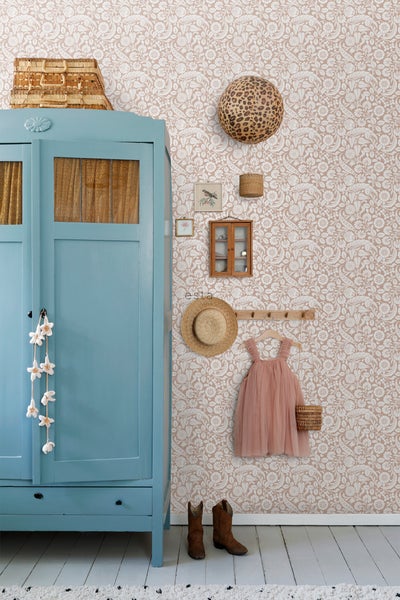 Kinderzimmer mit blauem Schrank, floraler Tapete, Accessoires und Kleid