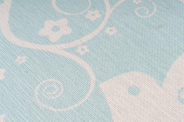 Vliestapete mit weißem Blumenmuster und Schnörkeln auf hellblauem Grund, strukturierte Oberfläche.