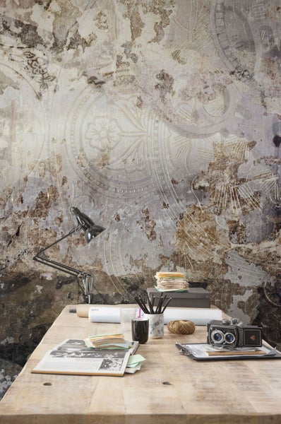 Szene mit einer gemusterten Fototapete, einem Schreibtisch und verschiedenen Büroartikeln.