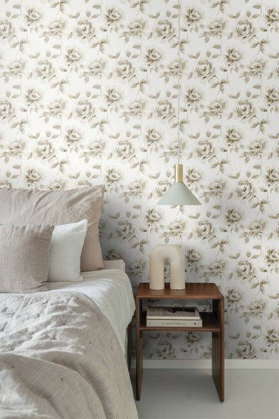 Schlafzimmer mit Bett, Nachttisch und Tapete mit Blumenmuster