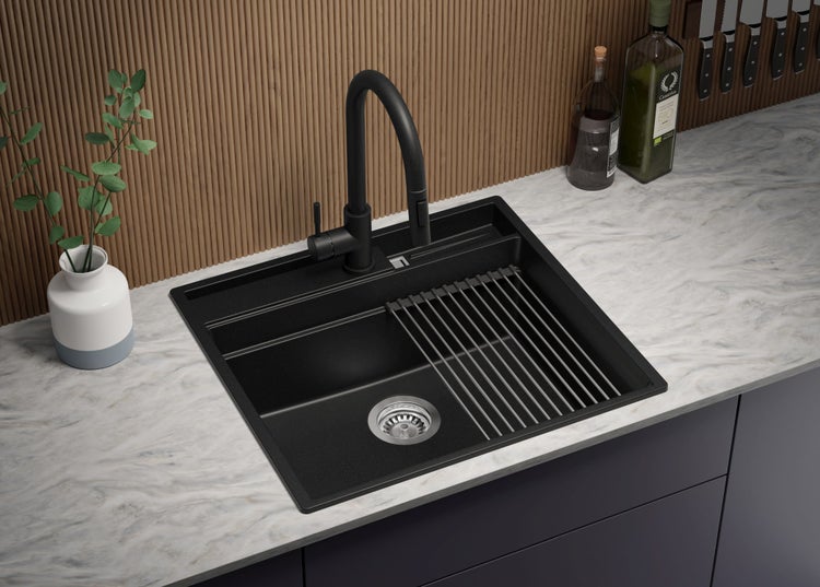 Schwarze Küchenspüle mit Abtropfgestell und Armatur auf einer Küchentheke