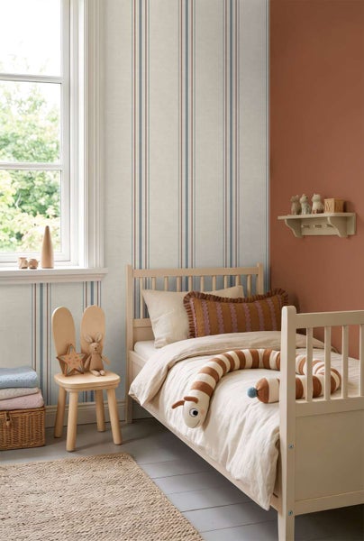 Kinderzimmer mit gestreifter Tapete in einem behaglichen Design mit Holzbett, passendem Stuhl, Spielzeug und einem Wandregal.