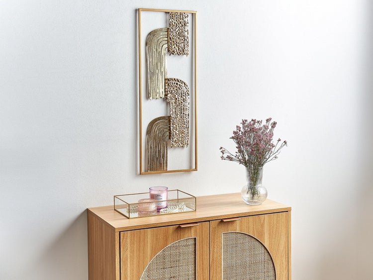 Dekorative Wandkunst über Kommode mit Kerze und Vase mit Blumen