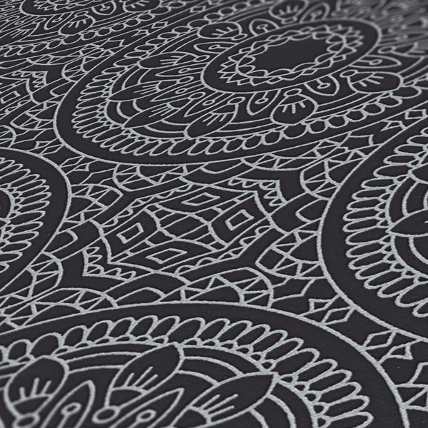 Dekorative Tapete mit Mandala Muster hinter einem Holztisch