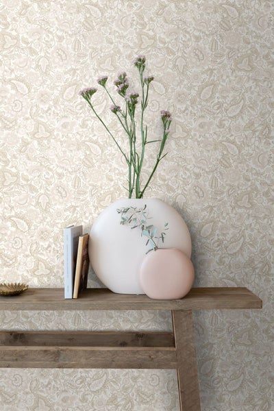 Vliestapete mit floralem Paisley-Muster hinter einer hölzernen Konsole mit dekorativen Vasen und Büchern.
