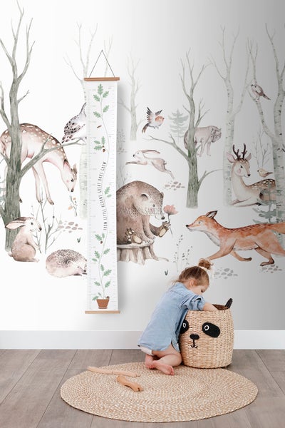 Kinderzimmer mit Waldtiertapete, Wachstumsmesslatte und Kind mit Panda-Spielzeugkorb