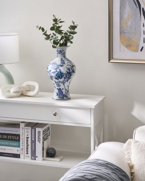 Dekoratives Arrangement mit einer blau-weißen Vase auf einem weißen Konsolentisch