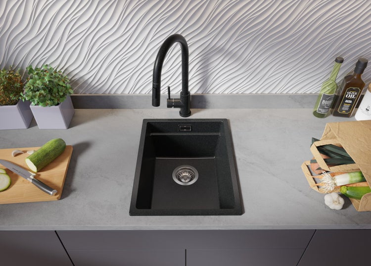 Küchenspüle mit Armatur, Schneidebrett und Lebensmitteln auf einer Küchentheke