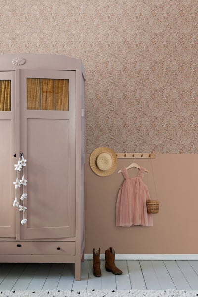 Dekoratives Kinderzimmer mit floraler Tapete, Schrank, Kleidung und Accessoires.