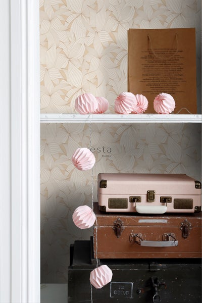 Dekoratives Regal mit Tapete, Papiergirlande und Vintage-Koffern