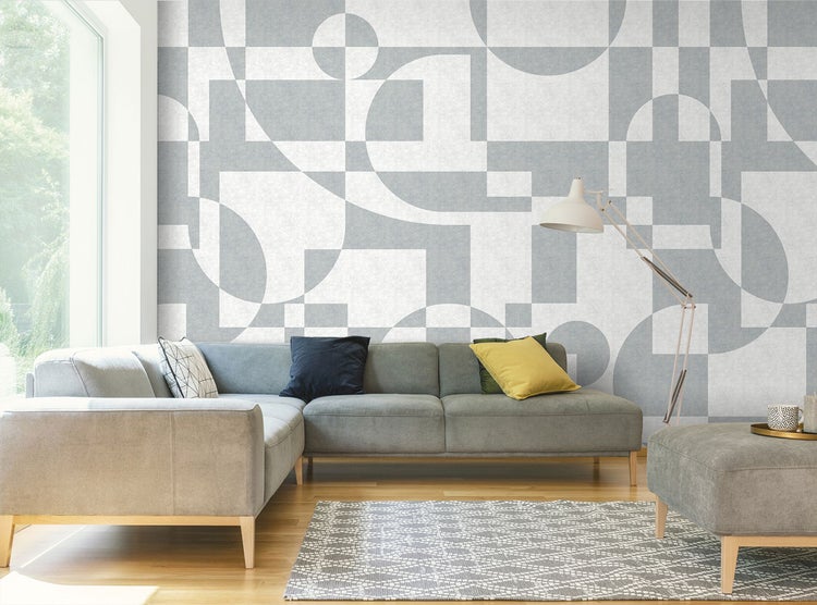 Wohnzimmer mit Sofa, Stehlampe und geometrischer Tapete