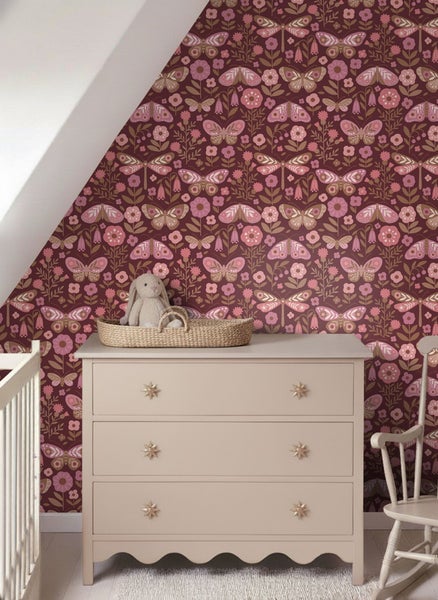 Kinderzimmer mit gemusterter Tapete, Kommode und Schaukelstuhl