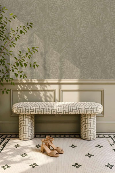 Wohnraum mit Vliestapete mit Palmenblattmuster, gepolsterter Sitzbank mit geometrischem Muster und Fliesenboden mit Mosaikdesign.