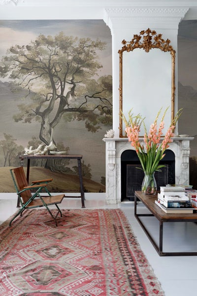 Wohnzimmer mit gemusterter Tapete, Kamin und Teppich