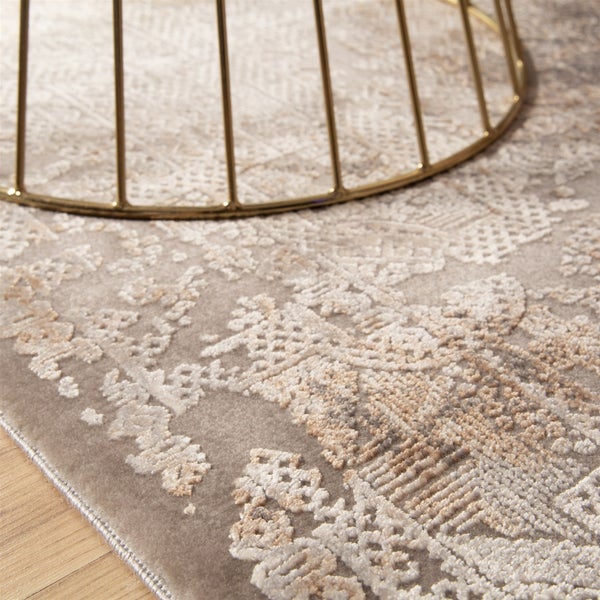 Nahaufnahme eines Teppichs mit Vintage-Muster und kurzem Flor auf einem Holzboden unter einem Metallgestell.