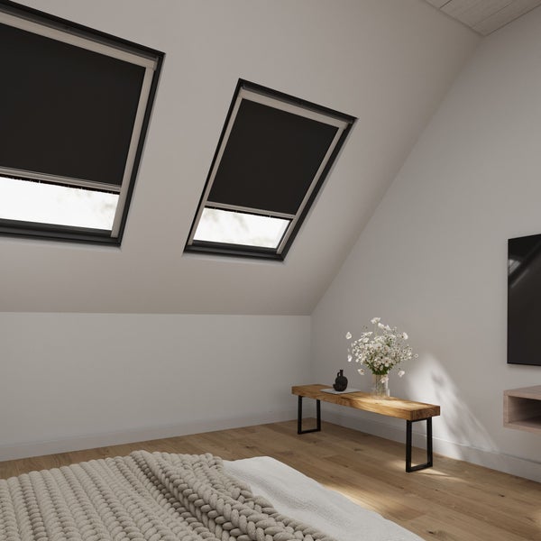 Schlafzimmer im Dachgeschoss mit zwei Dachfenstern und Verdunkelungsrollos.