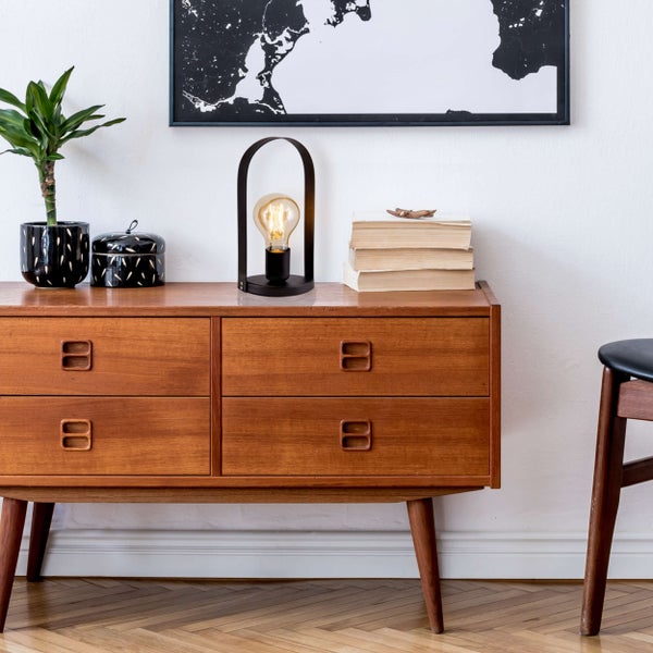 Dekoratives Interieur mit Kommode, Lampe und Zimmerpflanze