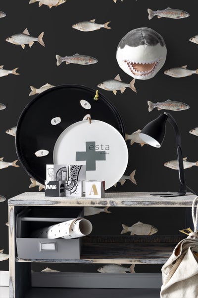 Dekoratives Interieur mit Fischtapete, Ablagetisch, Lampe und Deko-Elementen wie Hai-Kopf, Tablett und Spielwürfeln