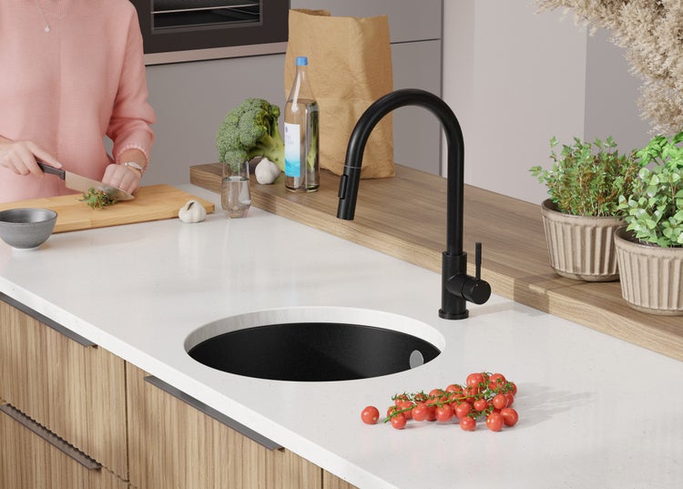 Küchenszene mit Spültisch, Armatur und Lebensmitteln auf der Arbeitsplatte